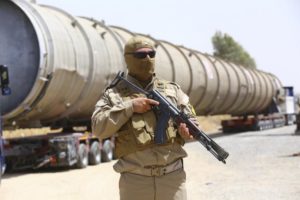 A Kurdish soldier guards a section of an oil pipeline